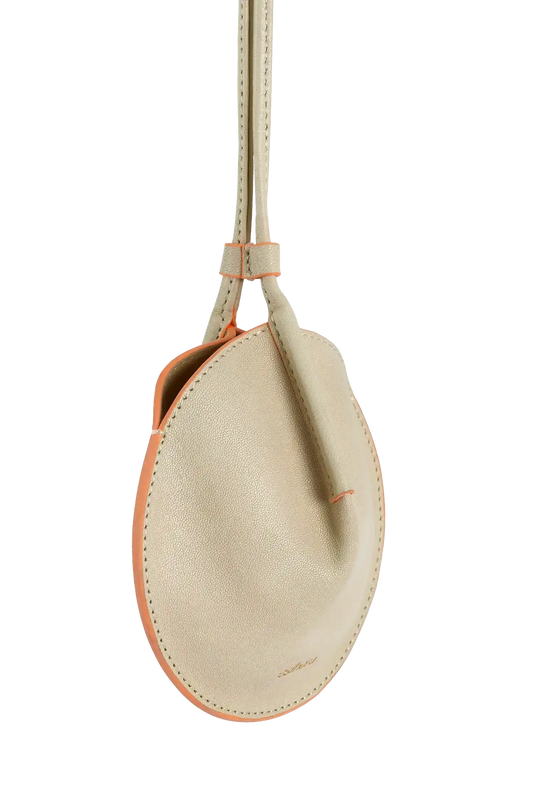 Bolsa circular em couro com alça longa e borda colorida, design brasileiro elegante